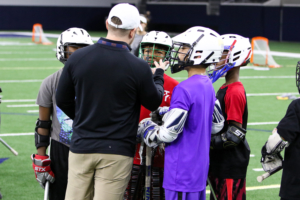 Bridge Lacrosse players get tips from a volunteer coach. 